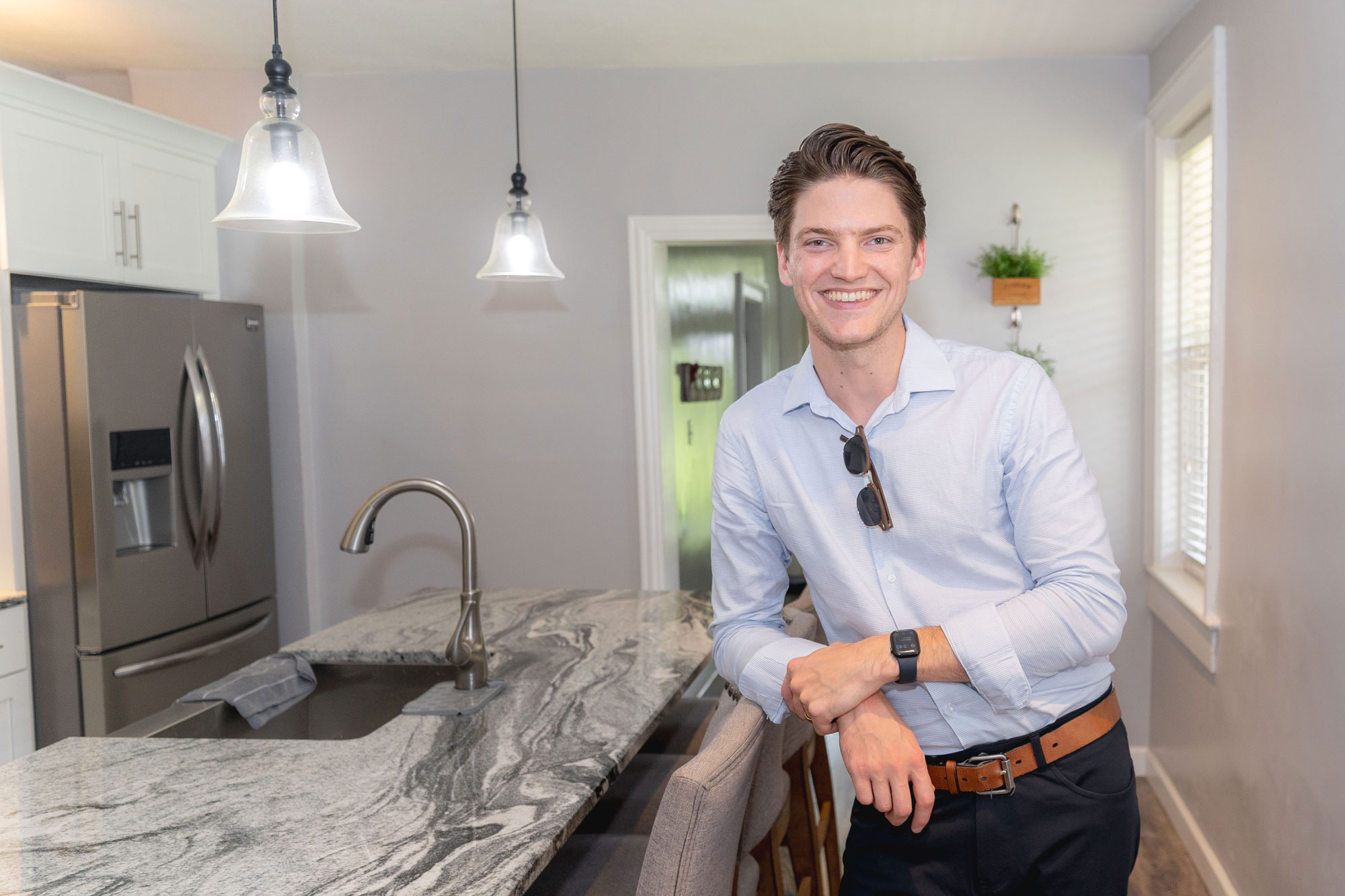 Photo of Real Estate Agent Caleb Williams standing and smiling warmly in a home's kitchen